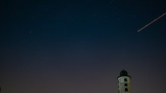 white and black lighthouse under starry sky