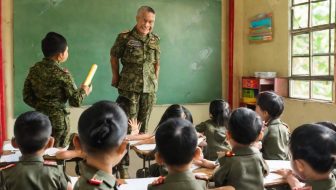 A military teacher explains in front of the class